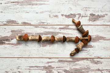 arrow indicates the direction of the autumn wild mushrooms on a background of old worn boards