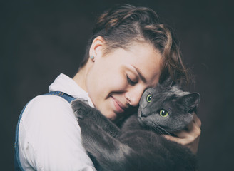 Beautiful young woman with blue Russian cat. Love for pet. Studi