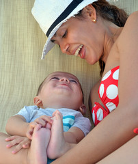 Madre con su bebe disfrutando juntos en la hamaca de vacaciones.