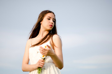 girl walking in a field with a flower