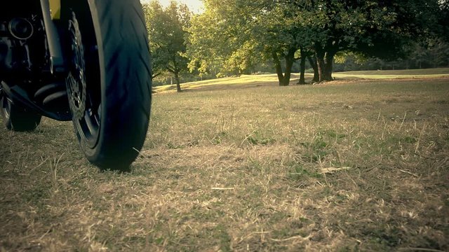 motorcyclist slows down and stops on a lawn