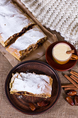 A cup of coffee, cinnamon, cake, knitted scarf - winter still life