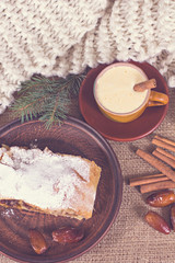 A cup of coffee, cinnamon, cake, knitted scarf - winter still life
