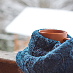 A cup with a hot drink on the background of the winter forest