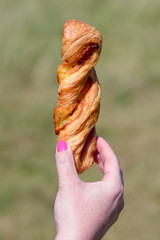 Woman holding cheese straw pastry in hand