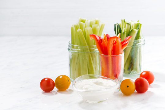 healthy snacks, mixed vegetables and yogurt on a white table
