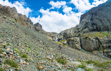 Fototapeta premium A group of tourists on a rocky slope, Kyrgyzstan.