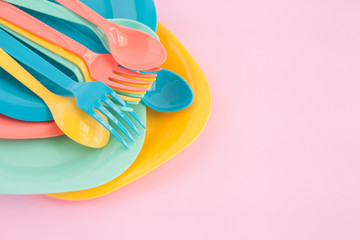  fork ,knife and spoon put on colorful plastic plate at pink background