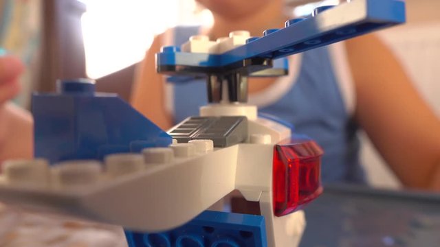 Boy playing with bright plastic construction set. 4K closeup video