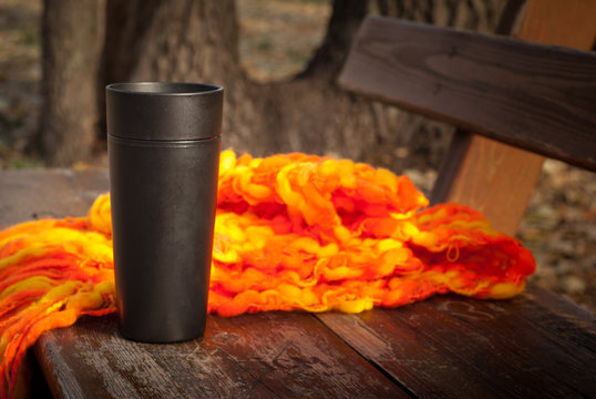 Tea in a thermos in autumn park.