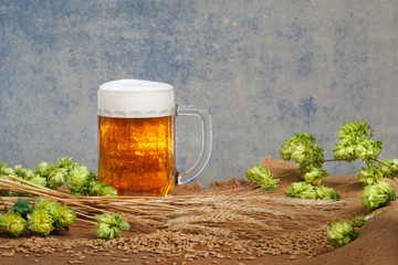 still life with glass of beer and raw material for beer producti