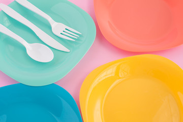  fork ,knife and spoon put on colorful plastic plate at pink background