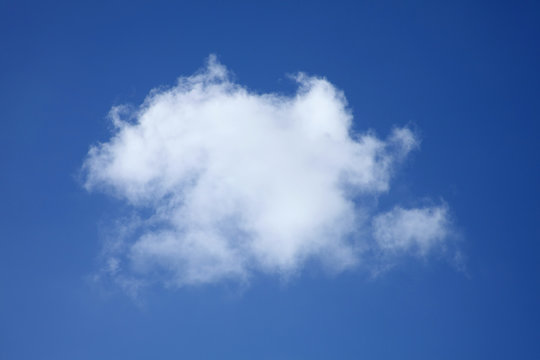 Background of a one single fluffy cumulus cloud in a blue clear sky