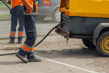 Unidentifiable road maintenance workers repairing driveway