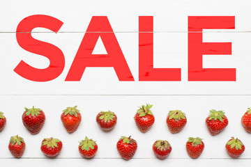 Word Sale painted on white wooden table. Strawberry pattern