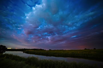 Storm clouds in the sky after sunset on the river.