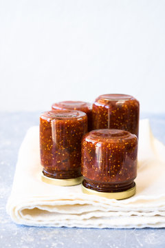 Small jars turned upside down and filled with homemade fig jam. Selective focus, copy space.