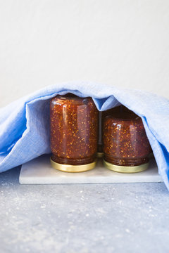 Small jars turned upside down and filled with homemade fig jam. Selective focus, copy space.