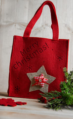 Red festively decorated bag on a wooden background.