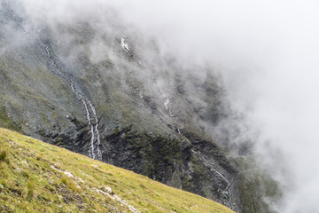 Alpine Berglandschaft mit Sturzbach und Wolkenwand