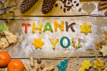 Cookie letters with christmas decoration on wooden table, thank
