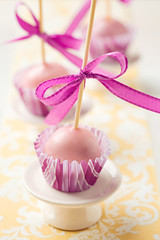 Pink Christmas cake pops sticking upside down in miniature cupcake liners. Very shallow depth of field