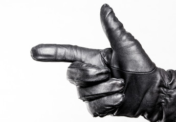 Hand in black leather glove. Gun shape hand pointing direction.