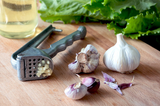 Crushed garlic. Fresh garlic bulbs on kitchen table. 