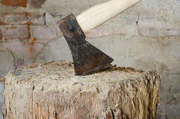 old wood chopping axe on a wooden trunk block in barn