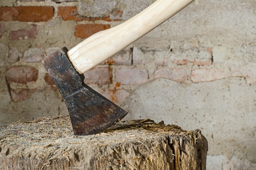 close up of an old rusty wood chopping axe in a barn