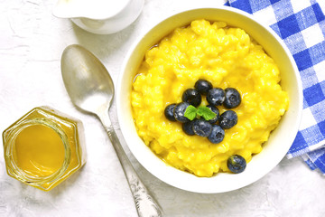 Rice porridge with pumpkin and fresh blueberry.Top view.