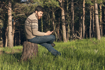 Obraz premium Young man in the woods enjoying a sunny afternoon