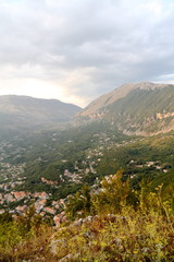 Obraz premium Cima di montagna verso la vallata incrociata da fiori e pease italiano