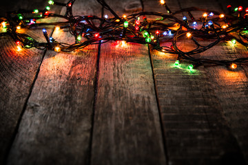 Christmas lights on dark wooden background with copyspace