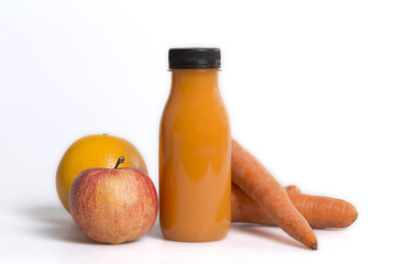 Carrots orange and apple juice in a bottle on a white background