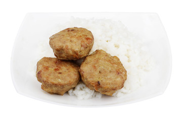 isolated three cutlets and white rice in white square plate on a white background.