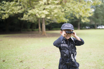 双眼鏡で遠くを見る警察の衣装を着た女の子