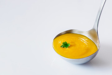 Ladle with fresh homemade carrot ginger soup