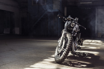 Motorrad steht in dunklem Gebäude in Sonnenstrahlen