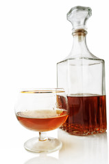 Shot glass and decanter with alcohol on a white background with