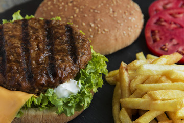 Beef hamburger  grill french fries pickled cucumber tomato cheese