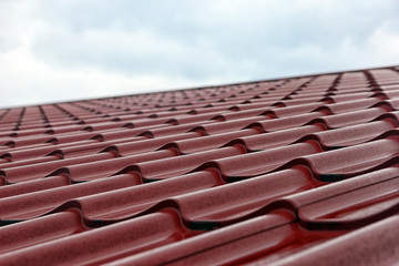 wet red metal roofing from sheet metal with droplets of rain clo