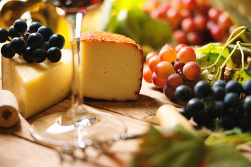 Glass of wine, grape and chesse on a table