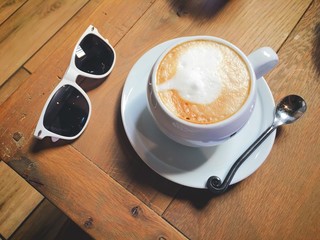 Coffee and sunglass on a wood table - 121373434