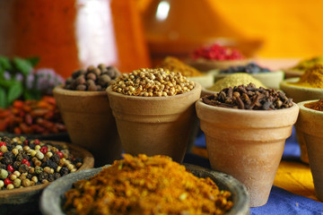 Collection of different spices in old clay bowls in colorful oriental style