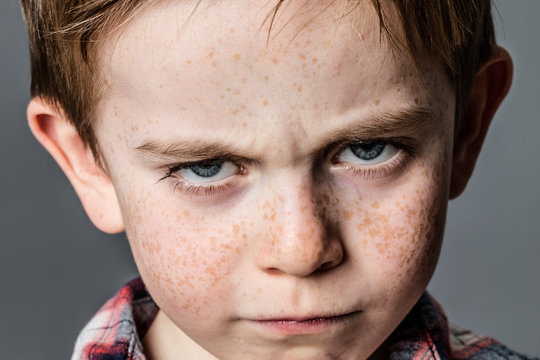 mad little kid with furious blue eyes for childhood rebellion