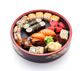 Japanese cuisine. Sushi set on a round wooden plate isolated on white background