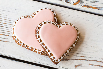 Pair of heart-shaped biscuits. Light pink icing on cookies. Unforgettable taste of love. Small delicious gift.