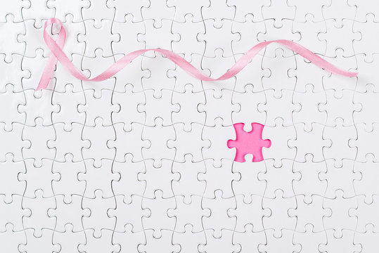 Pink ribbon and puzzle pieces breast cancer.