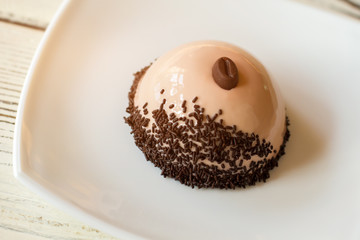 Small dome shaped dessert. Cake with beige frosting. Mirror glaze and coffee mousse. New flavor and design.